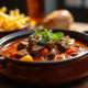 Carbonade flamande dans un bol en céramique rustique sur une table en bois