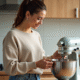 Femme détachant le bol d'un mixeur en cuisine chaleureuse