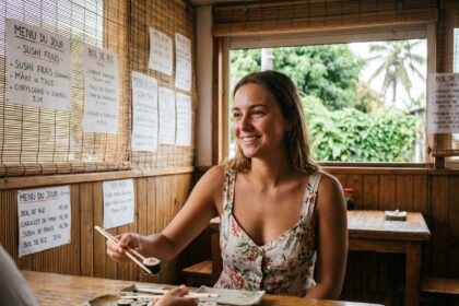 Jeune femme souriante mangeant des sushis dans un restaurant japonais à La Réunion